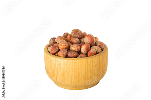 nuts of Turkish hazel in a composition with money wooden bowl and spoon scattered on a table isolate on a white background