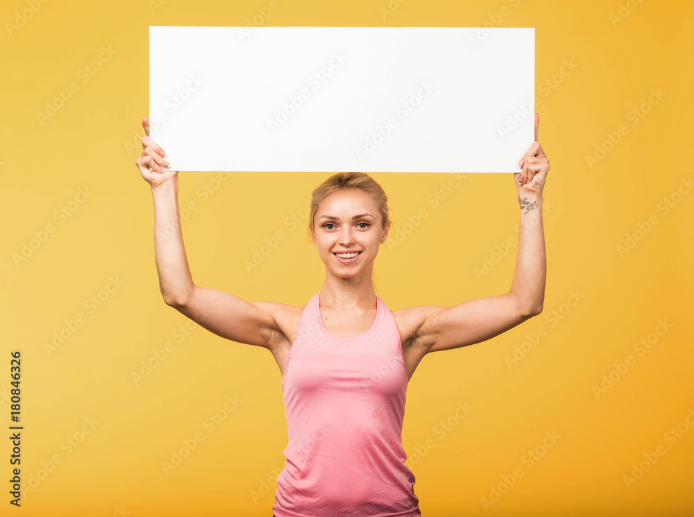Young glad woman portrait of a confident businesswoman showing presentation, pointing placard yellow background. Ideal for banners, registration forms, presentation, landings, presenting concept. Young glad woman portrait of a confident businesswoman showing presentation, pointing placard yellow background. Ideal for banners, registration forms, presentation, landings, presenting concept.