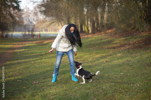 Young woman trains the dog in the autumn park.