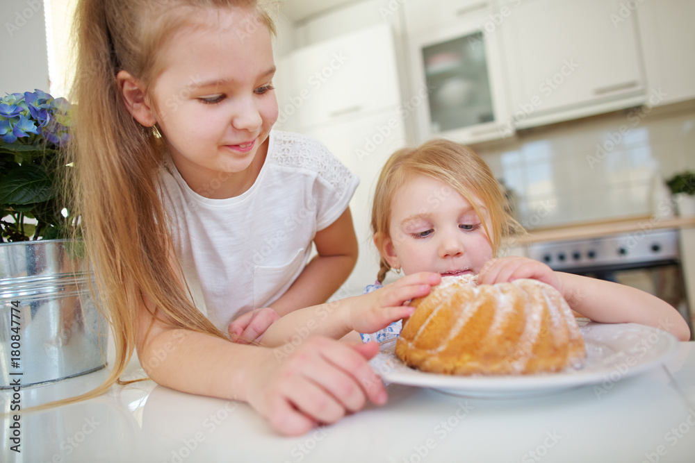 Zwei Kinder naschen von Kuchen in der Küche Zwei Kinder naschen von Kuchen in der Küche