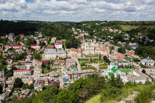 Top aerial city landscape close up view. Kremenets, Ukraine. Old buildings with peeling paint. Beautiful churches Baroque style and green park