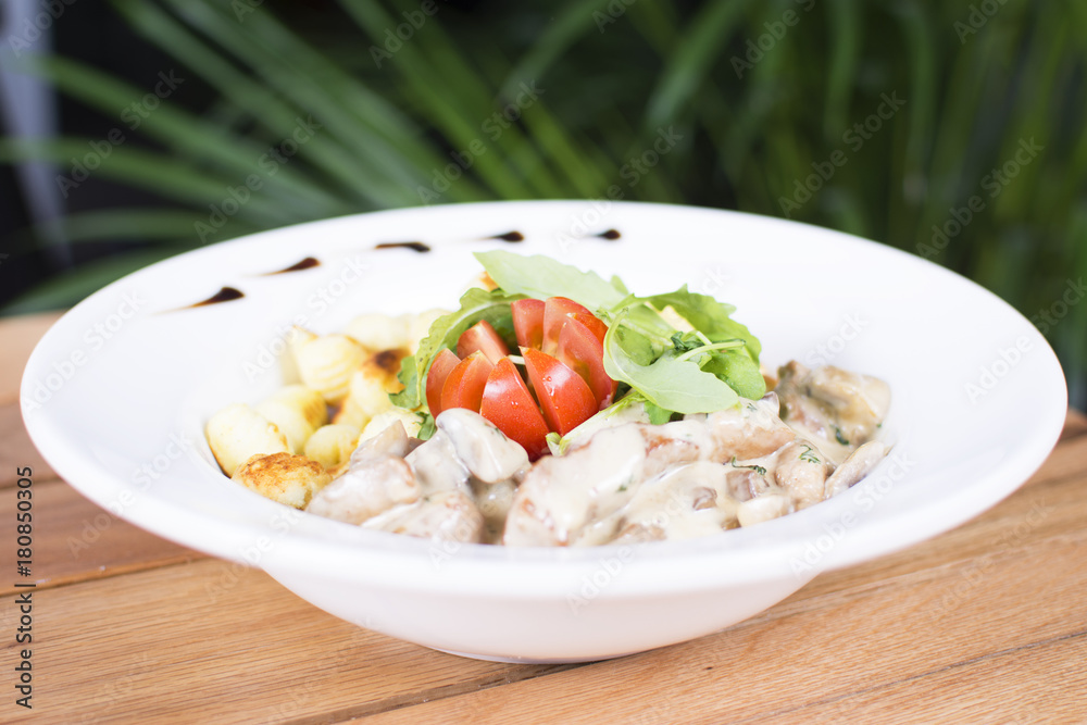 Nice meat with tomatoes with gnocchi. White cream topping with the touch of green seasoning. Beautifully served plate at the restaurant. Nice meat with tomatoes with gnocchi. White cream topping with the touch of green seasoning. Beautifully served plate at the restaurant.