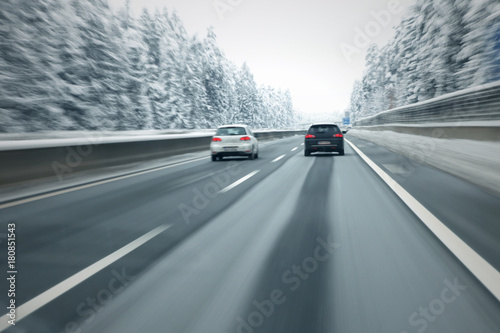 Motion blurred cars overtaking on slippery and frozen highway. Personal perspective used. © robsonphoto