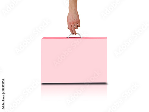 Hand holds a pink box with a handle. Packing box for laptop. Isolated on white background