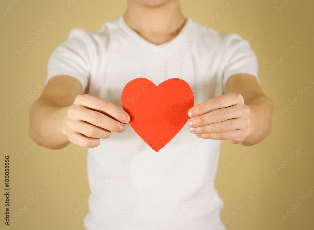Man hands holding blank empty red Valentines card with heart on a white background Man hands holding blank empty red Valentines card with heart on a white background