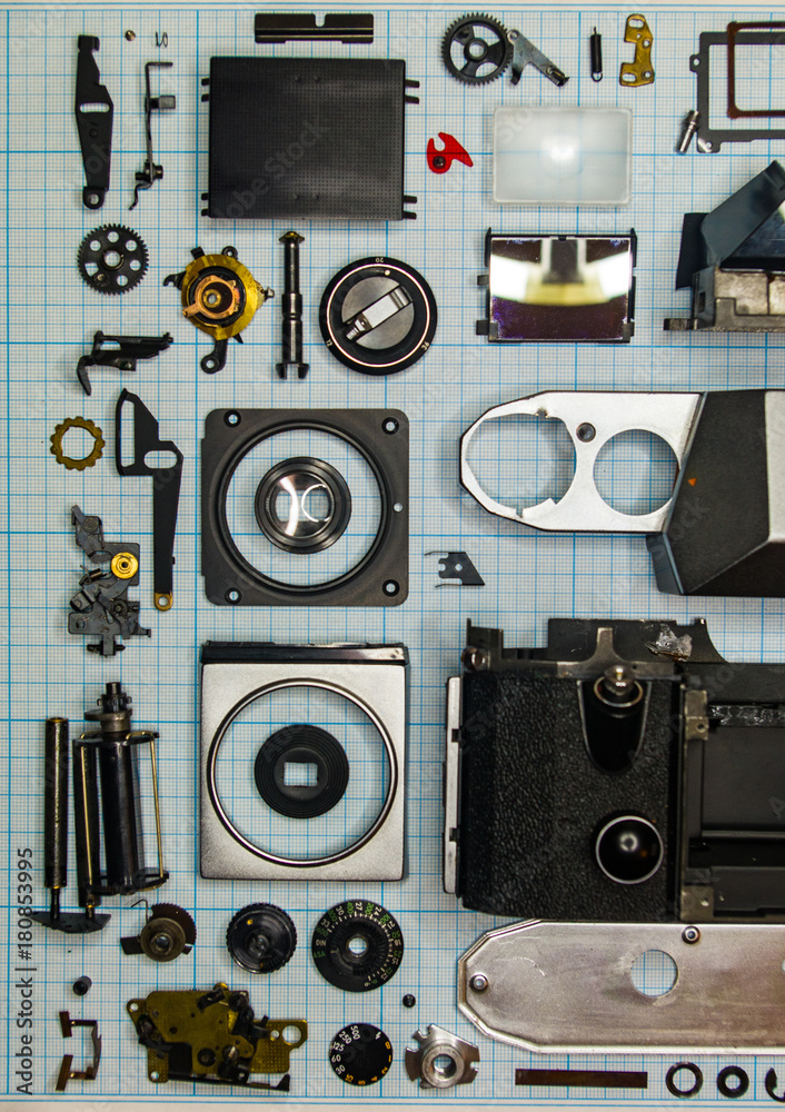 parts old retro film SLR camera on graph paper parts old retro film SLR camera on graph paper