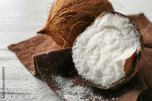 Desiccated coconut in nut on wooden table