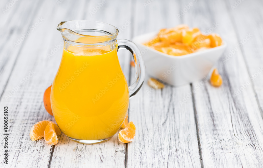 Wooden table with fresh made Tangerine Juice (close-up shot)