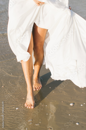 legs of a beautiful girl walking along the beach