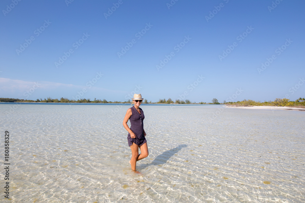 Girl walking in the water on the most beautiful beach of Cuba