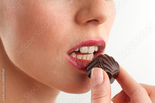 Model taking a bite from a praline
