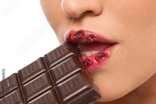 Model taking a bite of chocolate with red lips