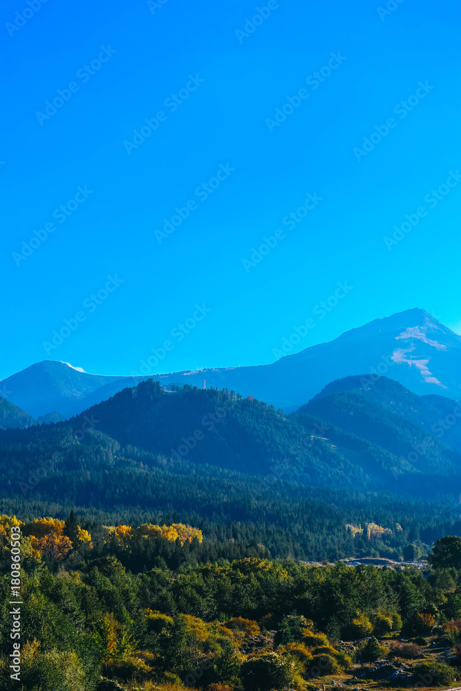 Beautiful view on the high green mountains peaks, on the blue sky background. Alpine Mountain hiking paradise landscape, no people.