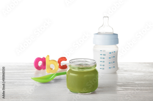 Composition with yummy baby food on wooden table against white background photo