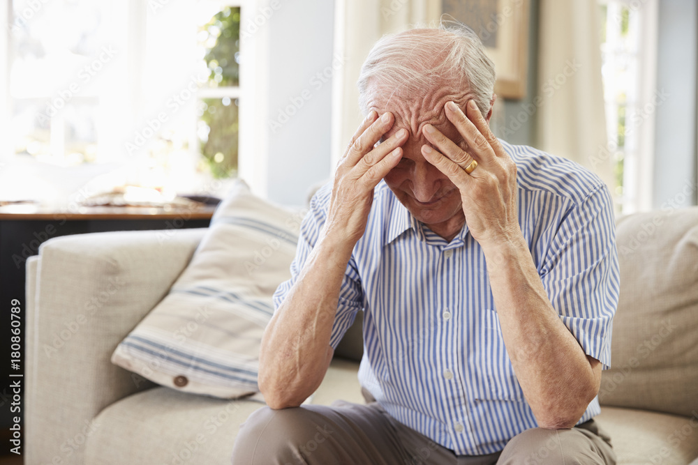 Senior Man Sitting On Sofa At Home Suffering From Depression - obrazy, fototapety, plakaty 