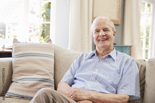 Portrait Of Smiling Senior Man Sitting On Sofa At Home © Monkey Business