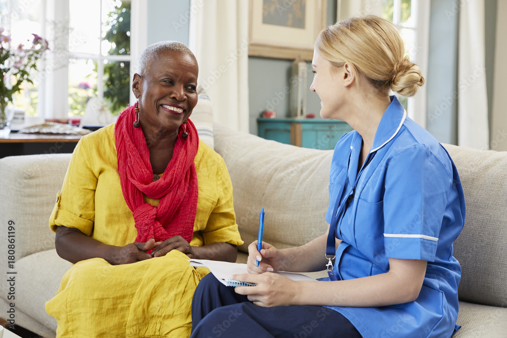 Obraz premium Female Community Nurse Visits Senior Woman At Home