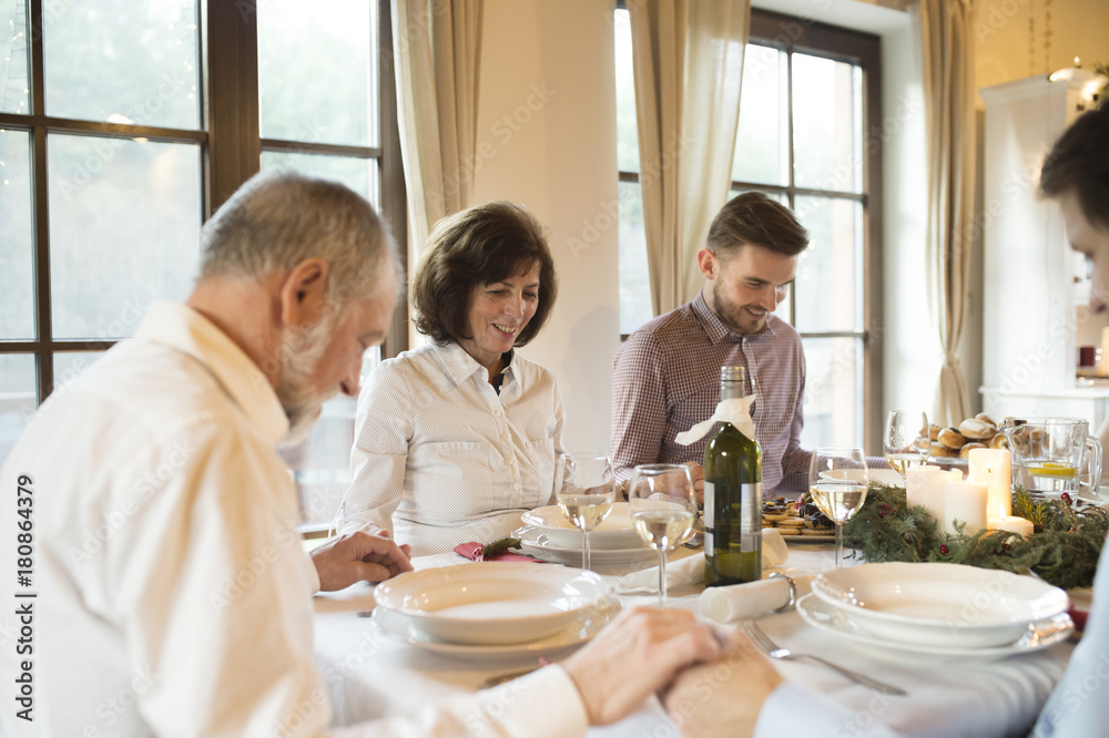 Family praying before Christmas dinner Family praying before Christmas dinner