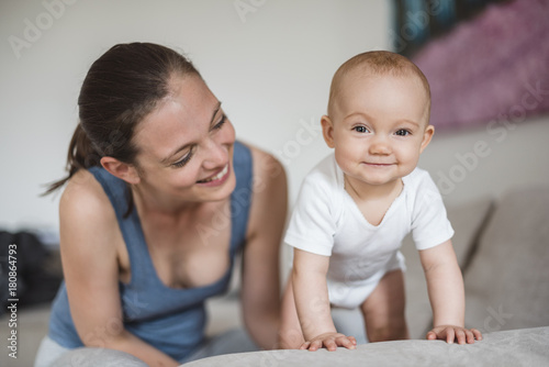 Portrait of baby girl with mother on couch