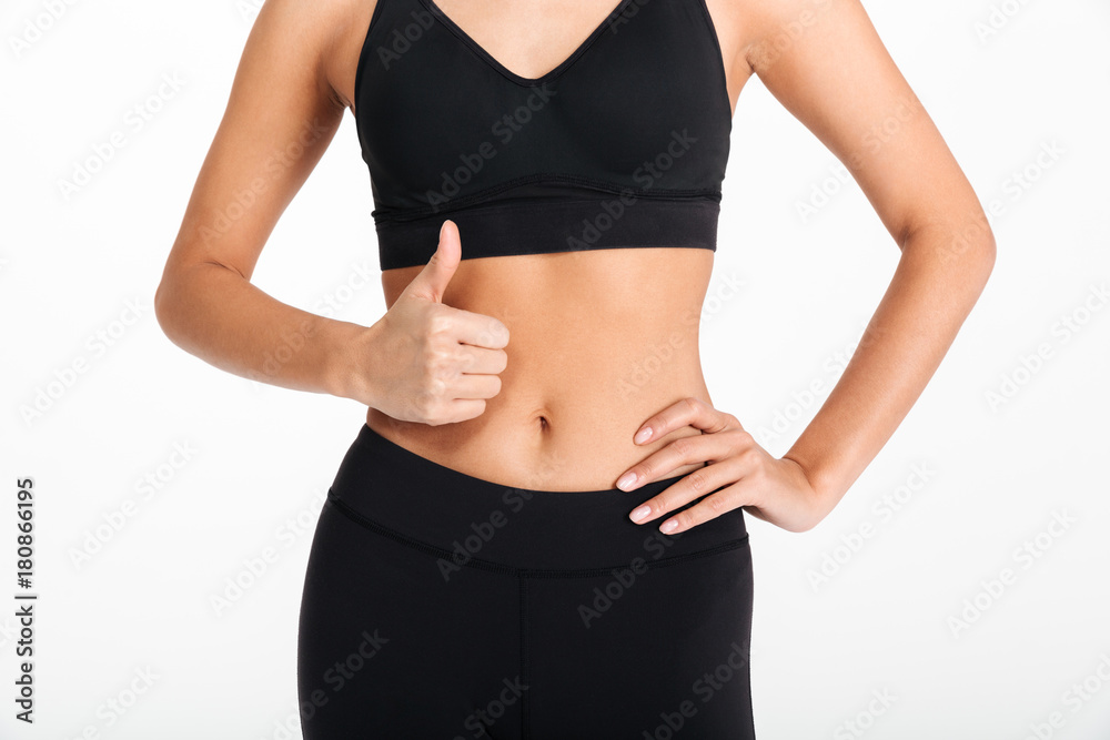 Cropped picture of young sports woman showing thumbs up. Cropped picture of young sports woman showing thumbs up.