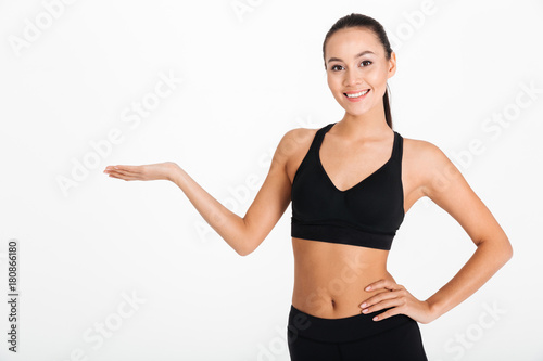 Beautiful young sports woman holding copyspace.