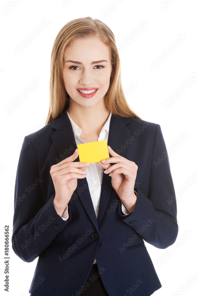 Beautiful caucasian business woman holding yellow empty personal card. Beautiful caucasian business woman holding yellow empty personal card.