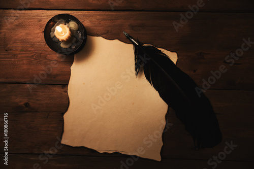 old paper and quill pen in candlelight. top view