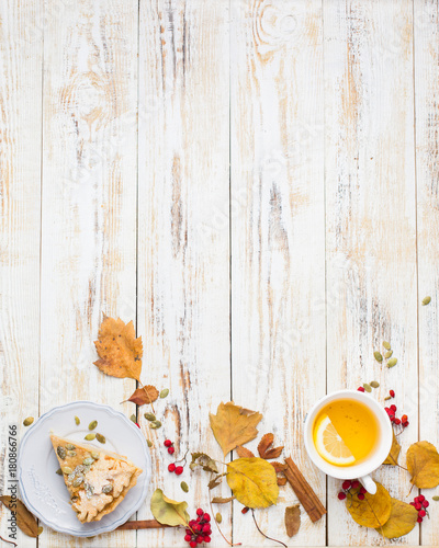 Autumn background with pumpkin pie  hot tea  yellowed leaves  book and rug. Perfect sunny autumn. A wooden light white autumn background for you. Copy Space. Place for text. Flat lay  top view
