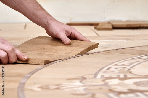 The carpenter installs one of the decorative elements of the parquet.