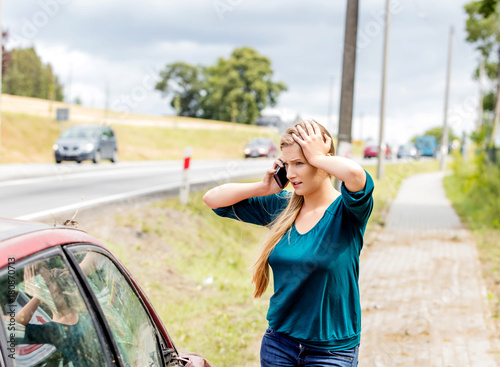 Woman dialing her phone after car crash