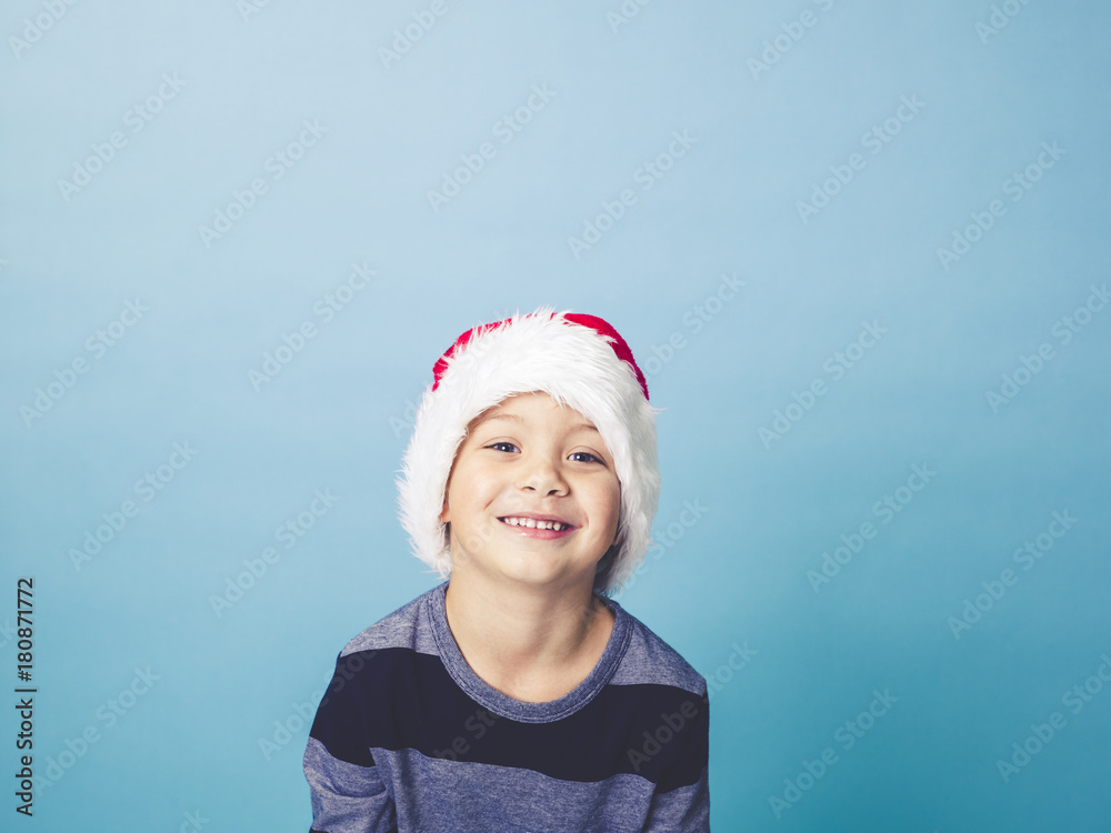 young 5 year old boy with christmas decoration on his hat young 5 year old boy with christmas decoration on his hat