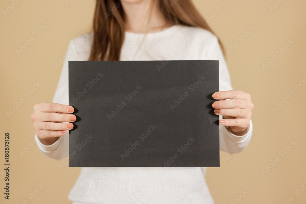 Girl holding black A4 blank paper vertically. Leaflet presentation ...