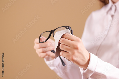 Women hand cleaning glasses lens with isolated background