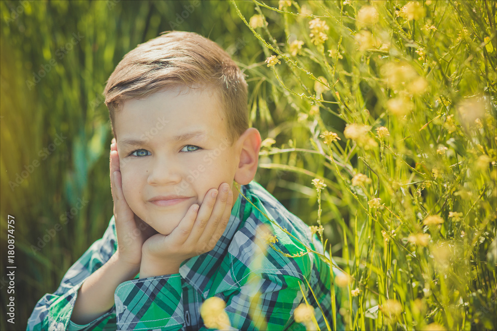 Handsome happy boy child enjoy posing summer time vacation on field yellow flowers wearing rustic village style clothes.Cute kid dreaming about future life Handsome happy boy child enjoy posing summer time vacation on field yellow flowers wearing rustic village style clothes.Cute kid dreaming about future life