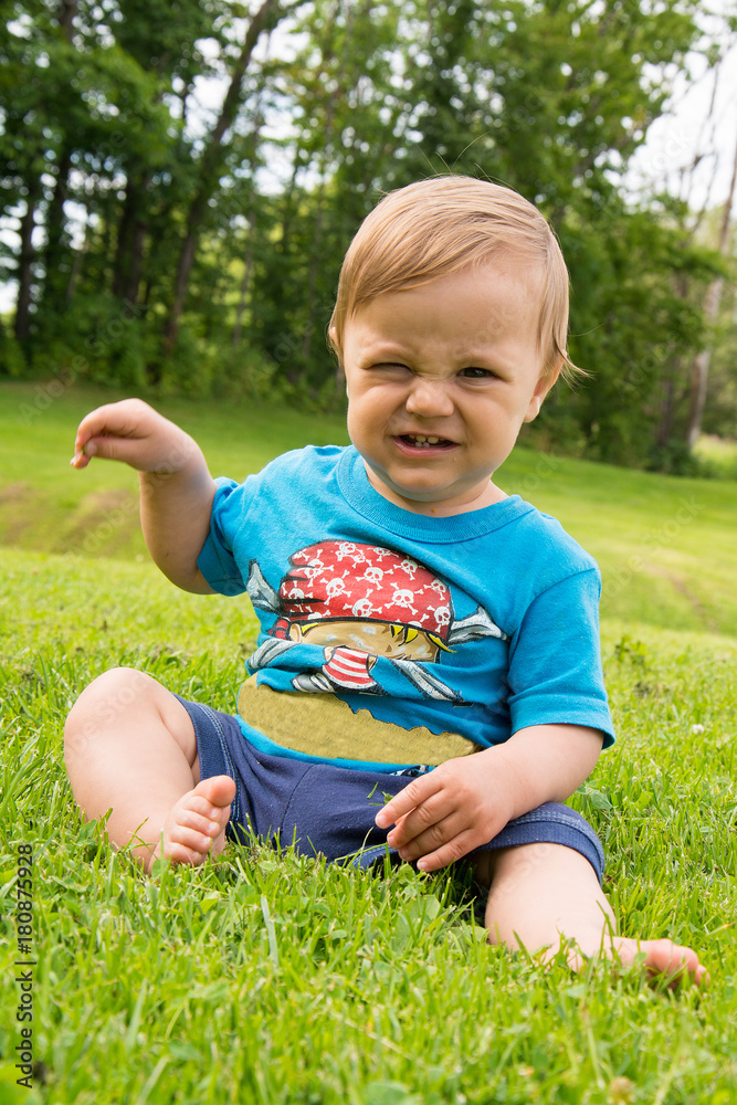 The boy is sitting on the grass and playing The boy is sitting on the grass and playing