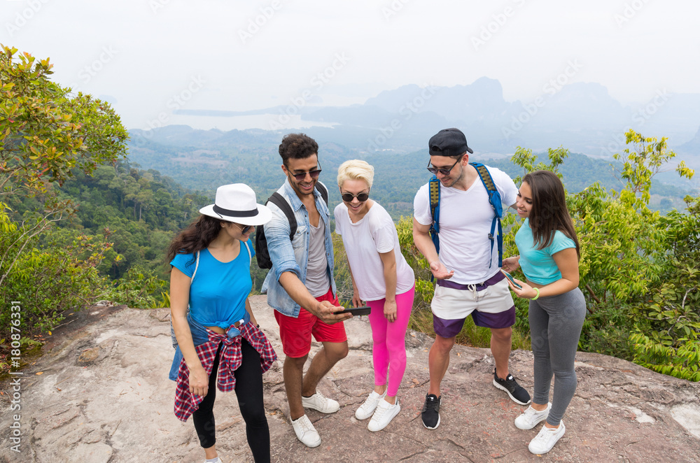 Tourist Group Watch Photos On Cell Smart Phones, People With Backpack Over Landscape From Mountain Top, Young Frineds On Hike Tourist Group Watch Photos On Cell Smart Phones, People With Backpack Over Landscape From Mountain Top, Young Frineds On Hike