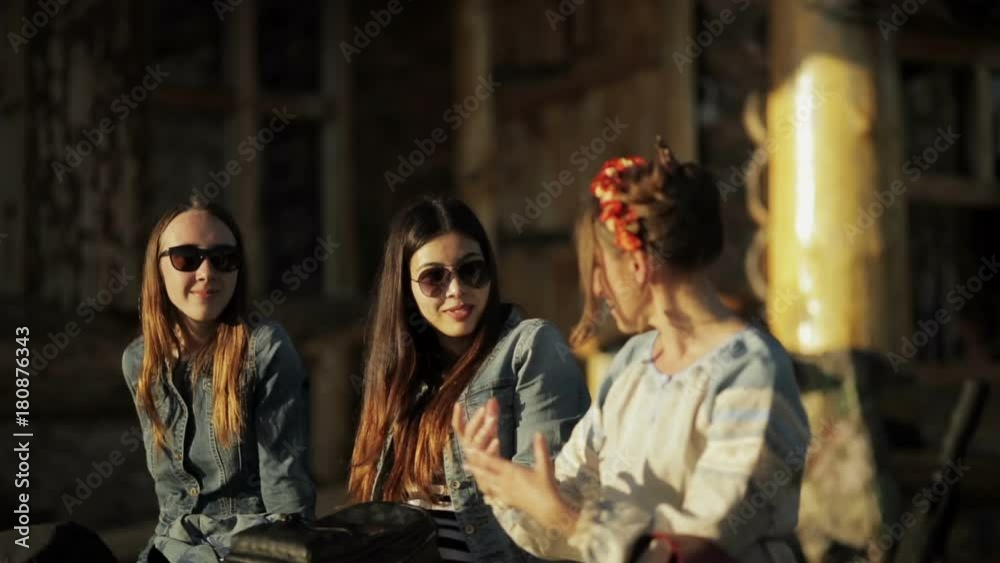 Girls talking and smiling sitting on a bench Girls talking and smiling sitting on a bench