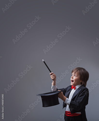 Magician boy performing with magic wand and hard hat