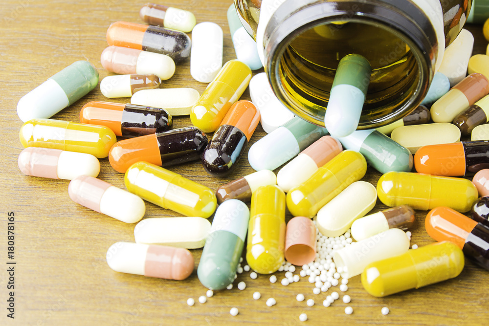 Medicine pills or capsules on wood background.Drug prescription for treatment medication.Pharmaceutical medicament,cure for health.Pharmacy theme, capsule pills with medicine antibiotic in packages. Medicine pills or capsules on wood background.Drug prescription for treatment medication.Pharmaceutical medicament,cure for health.Pharmacy theme, capsule pills with medicine antibiotic in packages.