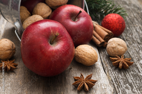 Red apples with christmas spices decoration on woden background	