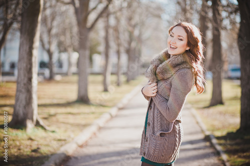 Mysterious adorable young brunette lady portrait with cute face and seducing lips professionally posing sit for camera wearing cosy warm designer clothes with fur in autumn spring central park photo