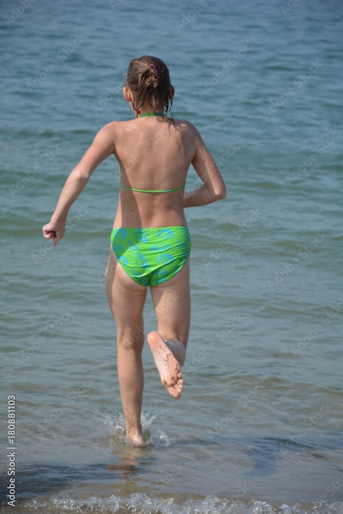 Mädchen von hinten, im Bikini rennt ins Meer