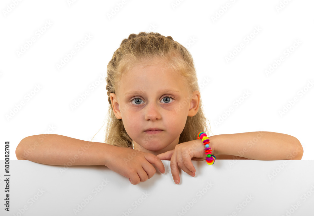 Little cute girl peeks out from behind the banner, isolated on white