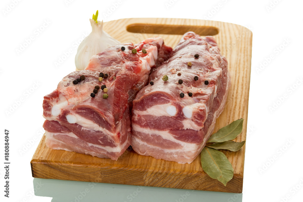 Two pieces of fresh pork and spices on cutting Board isolated on white
