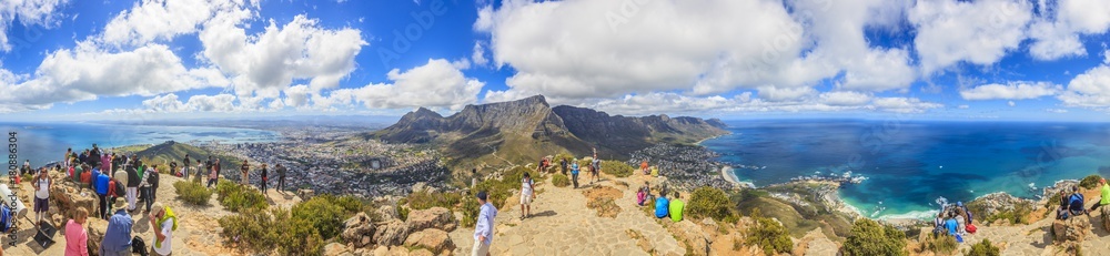 Panoramaaufnahme vom Gipfel des Lion Head mit Blick auf Kapstadt sowie den Tafelberg und Camps Bay tagsüber mit blauem Himmel und weißen Wolken fotografiert in Südafrika im September 2013