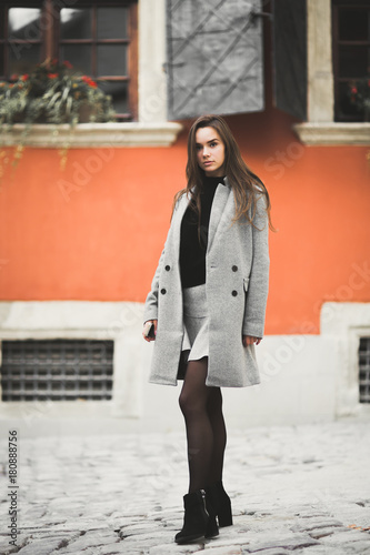 Fashion woman portrait of young pretty trendy girl posing at the city in Europe