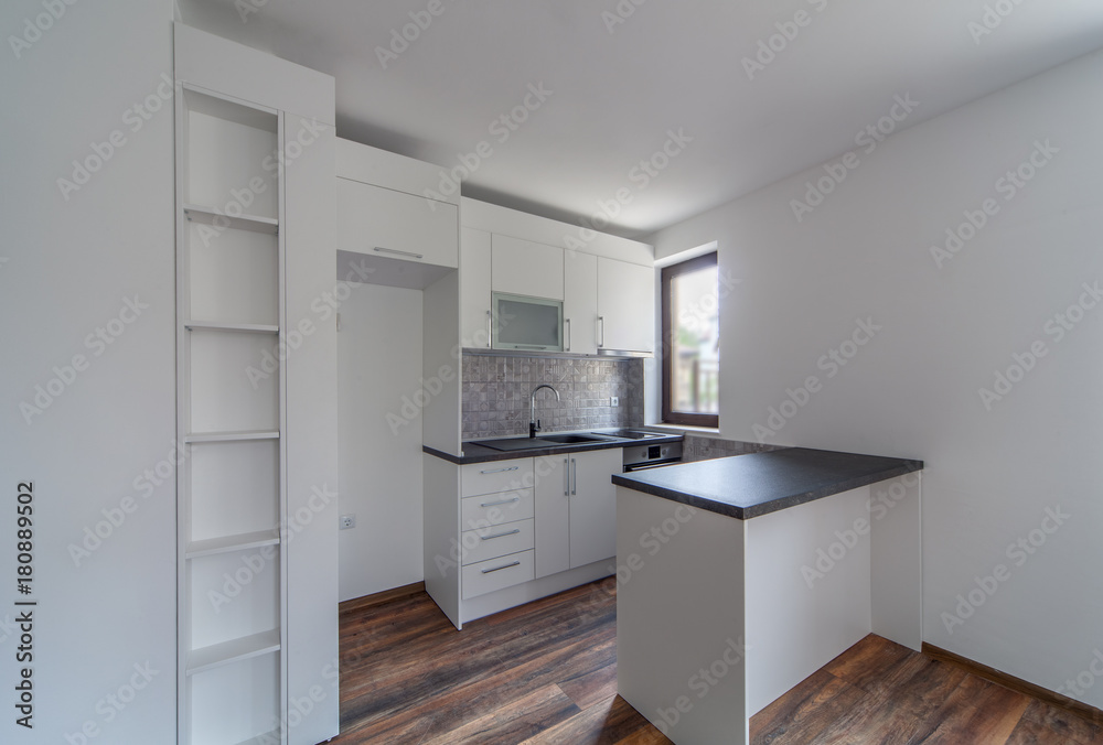 New modern and empty white kitchen. New home. Interior photography. Wooden floor.