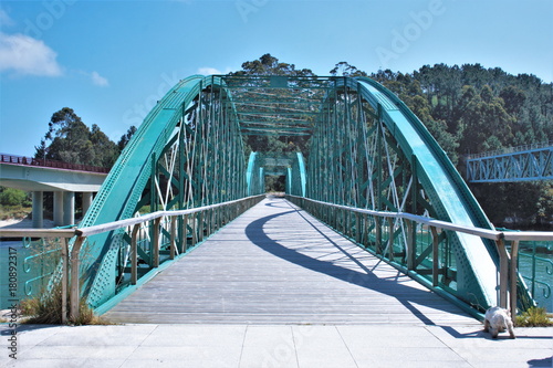 Iron pedestrian bridge , Eiffel school, over the mouth of a river Sor, estuary of O Barqueiro, A Coruna, Galicia, Spain,  photo