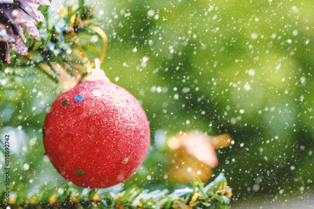 Obraz premium Red Christmas ball decoration hanging on tree with snow effect