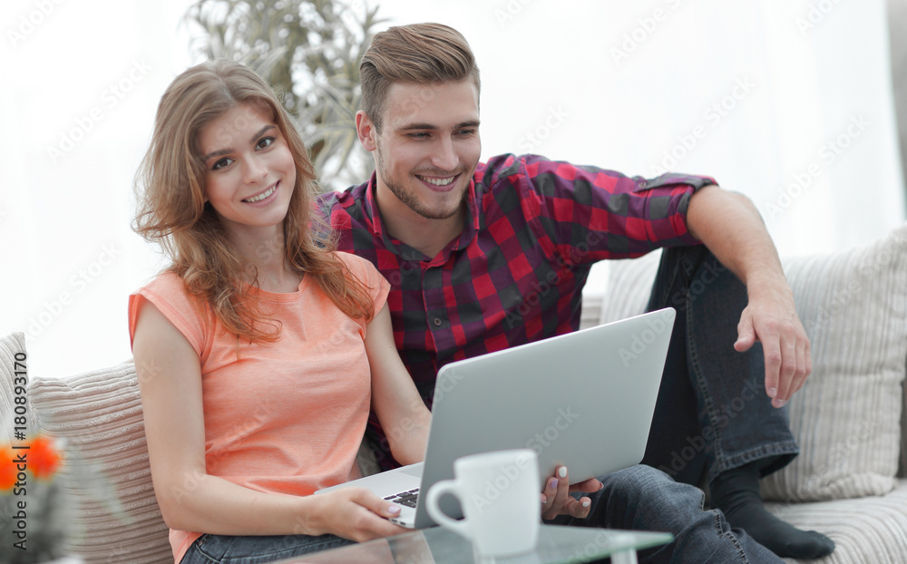 young couple .working on laptop sitting on sofa